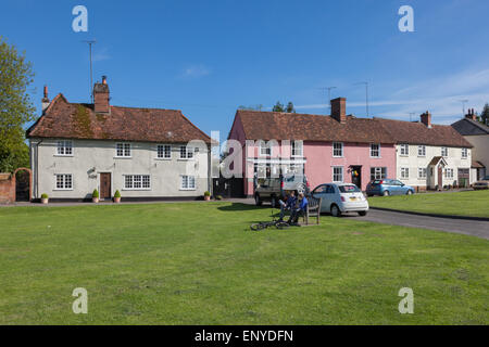 Deux cyclistes garçon reste sur un banc d'onFinchingfield Finchingfield, village green, Essex, Angleterre, RU Banque D'Images