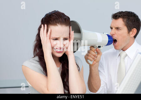 Businessman yelling avec un porte-voix à une femme d'affaires Banque D'Images