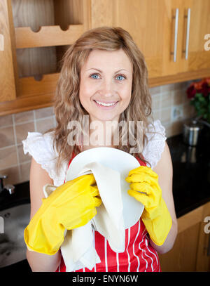 Smiling woman drying dish Banque D'Images