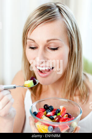 Belle femme de manger une salade de fruits Banque D'Images