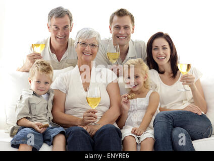 Portrait de famille boire du vin et manger des biscuits pour enfants Banque D'Images