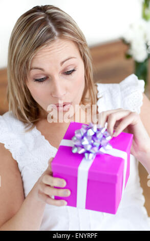 Surpris de l'ouverture d'une femme assise sur le sol cadeau Banque D'Images