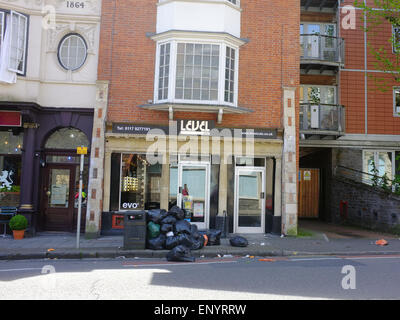 Une pile de sacs poubelle à l'extérieur d'une boutique à Bristol. Banque D'Images