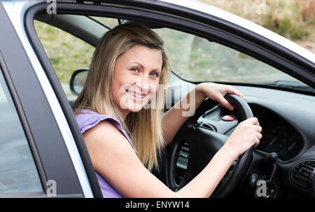 Heureux conductrice au volant assis dans sa voiture Banque D'Images