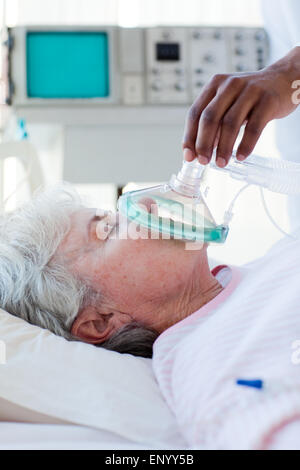 Un doctor putting oxygen mask on a patient Banque D'Images