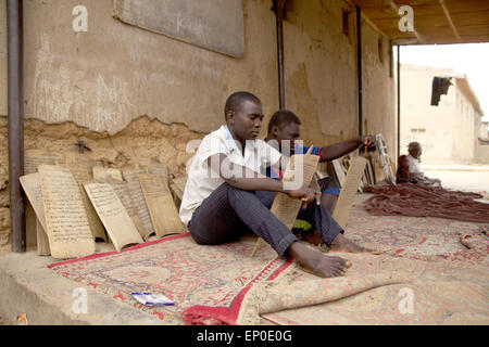 Kano, Nigéria. 06Th avr, 2015. Les garçons s'asseoir dans la cour d'une école coranique Almajiri à Kano, au Nigeria, 01 avril 2015, et lire des extraits du Coran sur des tablettes de bois. Le Gouvernement nigérian estime qu'il y a autour de 9 millions d'étudiants Coran Almajiri dans la région. Le terme "Almajiri" signifie "immigrant" en arabe. Photo : Kristin Palitza/dpa/Alamy Live News Banque D'Images