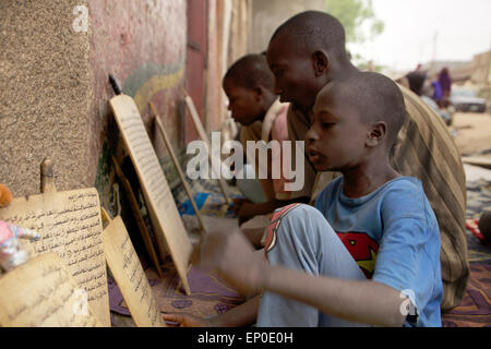 Kano, Nigéria. 06Th avr, 2015. Les garçons s'asseoir dans la cour d'une école coranique Almajiri à Kano, au Nigeria, 01 avril 2015, et lire des extraits du Coran sur des tablettes de bois. Le Gouvernement nigérian estime qu'il y a autour de 9 millions d'étudiants Coran Almajiri dans la région. Le terme "Almajiri" signifie "immigrant" en arabe. Photo : Kristin Palitza/dpa/Alamy Live News Banque D'Images