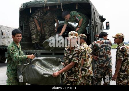 Katmandou, Népal. 10 mai, 2015. Des soldats népalais et singapouriens se décharger des approvisionnements de secours à l'aéroport international de Tribhuvan suite à des tremblements de terre qui ont frappé le royaume des montagnes 11 mai 2014 à Katmandou, au Népal. Banque D'Images