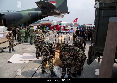 Katmandou, Népal. 10 mai, 2015. Des soldats népalais et singapouriens se décharger des approvisionnements de secours à l'aéroport international de Tribhuvan suite à des tremblements de terre qui ont frappé le royaume des montagnes, le 9 mai 2014 à Katmandou, au Népal. Banque D'Images