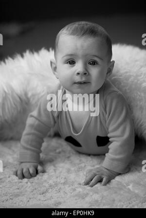 Baby Boy en noir et blanc à couverture en curieux Banque D'Images