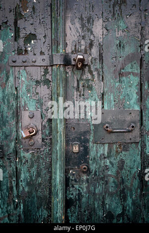 Vieille porte en bois vert avec un cadenas verrouillé Banque D'Images