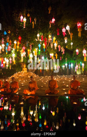 CHIANG MAI, THAÏLANDE - 6 NOVEMBRE 2014 : les jeunes moines bouddhistes méditant assis sous un arbre de bodhi à un festival des lumières. Banque D'Images