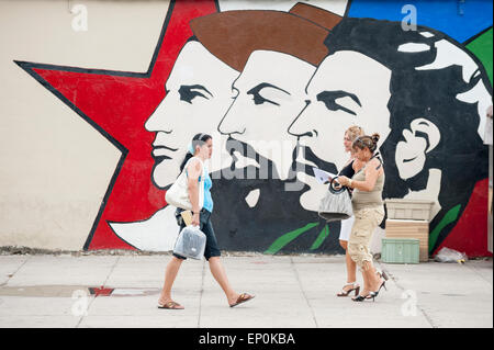 La HAVANE, CUBA - 13 juin, 2011 : pedestirans cubaine à pied en face de la propagande murale avec trois dirigeants de la révolution. Banque D'Images