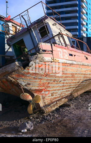 Vieux bateau de pêche en bois couché incliné le long de la route dans la région de Iquique, Chili Banque D'Images