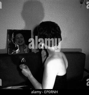 Deutsche Schlagersängerin Renee Franke benutzt Parfüm, Hamurg 1956. Schlager allemand singer Renee Franke à l'aide d'un parfum, d'H Banque D'Images