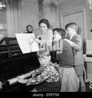 Kinder lernen bei ihrer Klavierlehrerin Klavier spielen, Hambourg 1956. Les enfants apprennent à jouer du piano avec leur enseignant. Banque D'Images