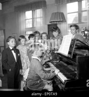 Kinder lernen bei ihrer Klavierlehrerin Klavier spielen, Hambourg 1956. Les enfants apprennent à jouer du piano avec leur enseignant. Banque D'Images