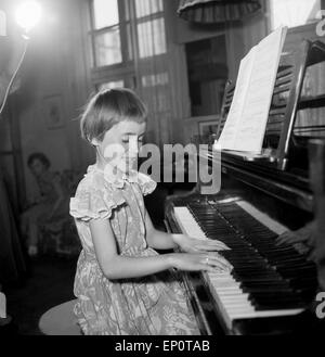 Ein Mädchen spielt une einem Flügel, Hambourg 1956. Une petite fille jouant un grand piano. Banque D'Images