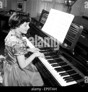 Ein Mädchen spielt une einem Flügel, Hambourg 1956. Une petite fille jouant un grand piano. Banque D'Images