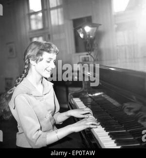 Ein Mädchen spielt une einem Flügel, Hambourg 1956. Une petite fille jouant un grand piano. Banque D'Images