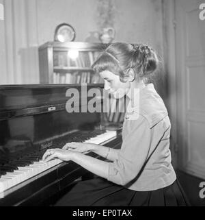 Ein Mädchen spielt une einem Flügel, Hambourg 1956. Une petite fille jouant un grand piano. Banque D'Images