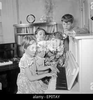 Kinder lernen bei ihrer Klavierlehrerin Klavier spielen, Hambourg 1956. Les enfants apprennent à jouer du piano avec leur enseignant. Banque D'Images