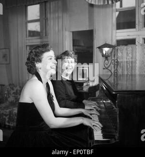 Spielt Eine Frau mit ihrer Klavierlehrerin une einem Flügel, Hambourg 1956. Une jeune femme jouant un duo avec son professeur à une gra Banque D'Images