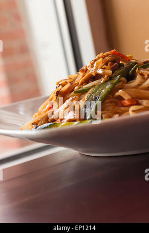 Pad Thaï épicé authentique avec du poulet servi avec légumes asiatiques Banque D'Images