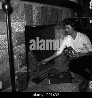 Deutsche Schauspielerin Gisela Lelim Michel zündet den Kamin, un Deutschland 1950 er Jahre. L'actrice allemande2312 éclairage Lelim Michel Banque D'Images