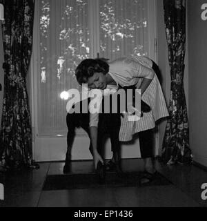 Deutsche Schauspielerin Gisela Lelim Michel im Flur mit ihren Dobermann, Deutschland 1950er Jahre. L'actrice allemande Gisela Lelim Michel Banque D'Images