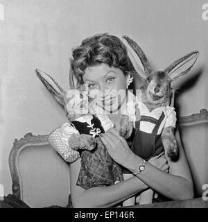 Deutsche Schauspielerin Gisela Lelim Michel mit zwei Osterhasen, Deutschland 1950er Jahre. L'actrice allemande Gisela Lelim Michel avec deux Banque D'Images