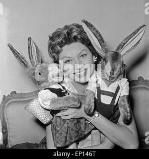 Deutsche Schauspielerin Gisela Lelim Michel mit zwei Osterhasen, Deutschland 1950er Jahre. L'actrice allemande Gisela Lelim Michel avec deux Banque D'Images