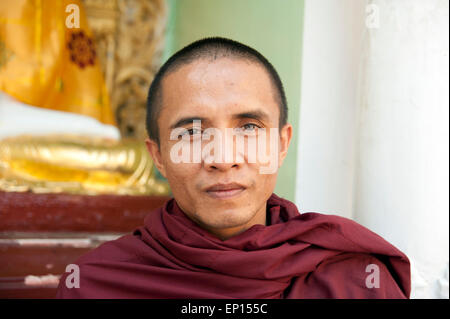 Un moine bouddhiste regarde la caméra à la pagode Shwedagon à Yangon Myanmar Banque D'Images