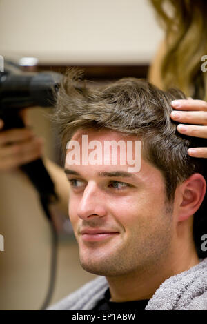 Coiffure femme homme son séchage des cheveux du client Banque D'Images