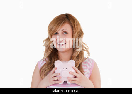 Attractive Woman posing while holding piggybank Banque D'Images