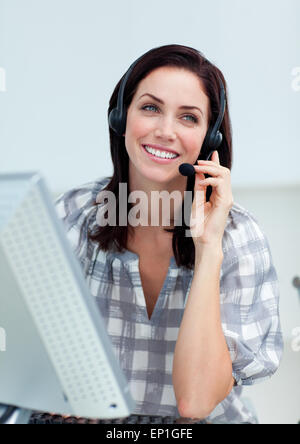 Radiant businesswoman with headset sur le travail à l'ordinateur Banque D'Images