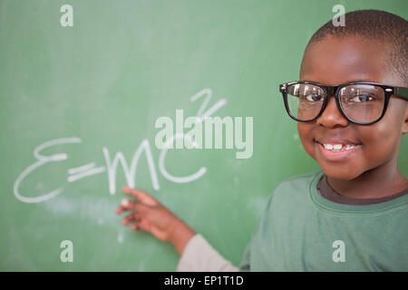 Smart schoolboy montrant l'équivalence masse-énergie Banque D'Images