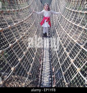 Fille debout sur un pont de corde Banque D'Images