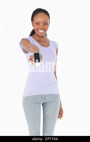 Close up of phone présenté par woman on white background Banque D'Images