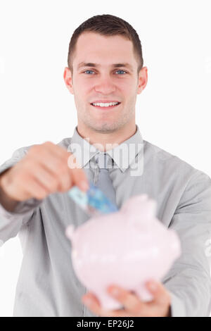 Portrait of a young businessman putting a vingt euros remarque dans un Banque D'Images