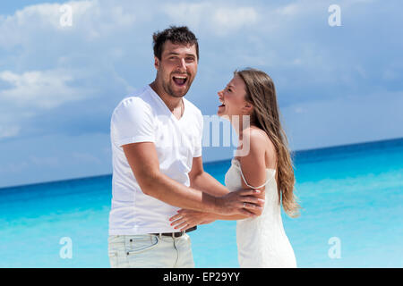 Happy smiling jeunes mariés s'amusant sur la plage, profiter de vacances tropicales Banque D'Images