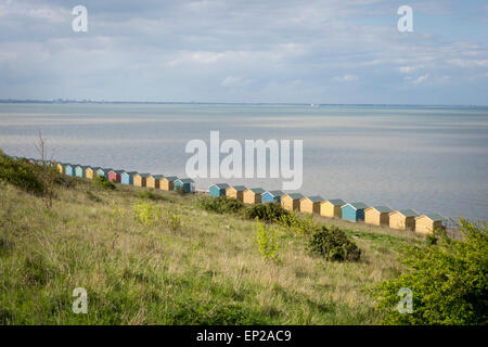 L'arrière d'une rangée de cabanes de plage face à la mer. Isle of Sheppey, Kent, UK Banque D'Images