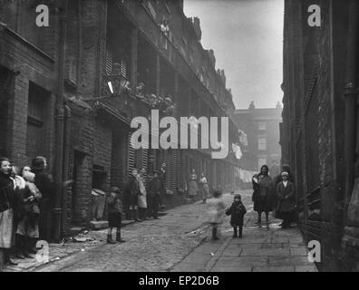 Les gens se tenant entre deux terrasses dans une zone de taudis de Liverpool. 2 mars, 1933. Banque D'Images