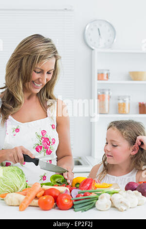 Mère de la préparation de légumes sur la table dans la cuisine Banque D'Images