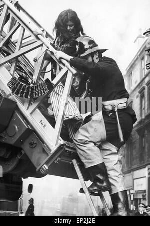 Incendie à Maryhill Road Glasgow. Feu dans un magasin de meubles inoccupés se propager le long de la rangée de boutiques et de piégeage des familles dans leurs maisons ci-dessus. Cinquante familles sont sans abri et d'une femme et d'un officier pompier ont perdu la vie. Samedi, 18 novembre 1972. Sur la photo, Mme Sylvia Mathieson qui est enceinte de son premier enfant a contribué à la sécurité par un pompier. Banque D'Images