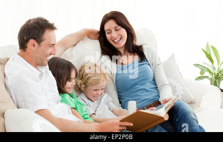 Heureux parents regardant un album photo avec leurs enfants Banque D'Images