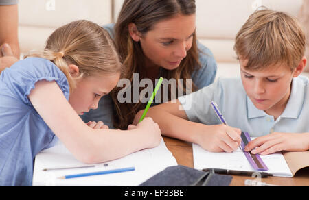 Mère d'aider ses enfants à faire leurs devoirs Banque D'Images