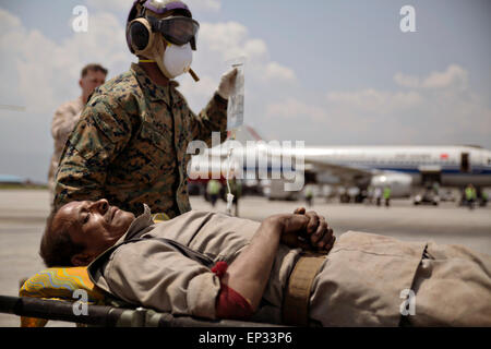 Katmandou, Népal. 13 mai, 2015. Un U.S. Marine aide à transporter un homme népalais à une zone de triage à l'aéroport international de Tribhuvan, 12 mai 2015 à Katmandou, au Népal. 7.3 Une ampleur aftershock séisme a frappé le royaume après la séisme de magnitude 7,8 le 25 avril. Banque D'Images