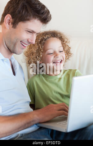 Portrait d'un mignon petit garçon et son père à l'aide d'un ordinateur portable Banque D'Images
