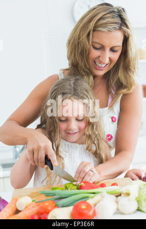 L'enseignement de sa fille mère couper des légumes Banque D'Images